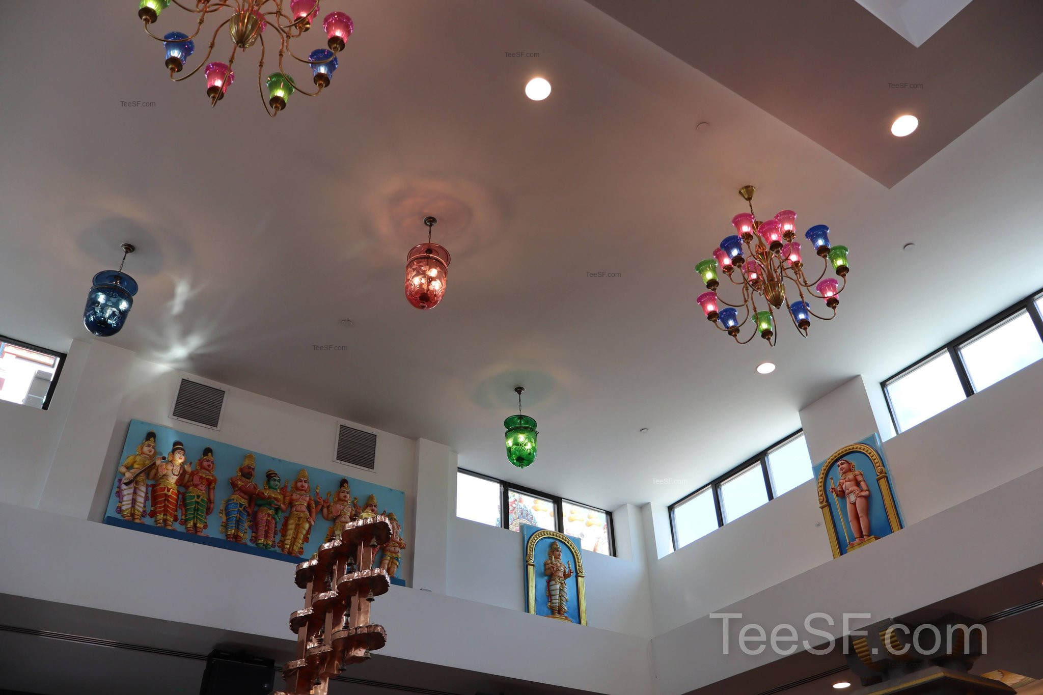 A quiet ceiling view with hanging ornaments and balcony details.